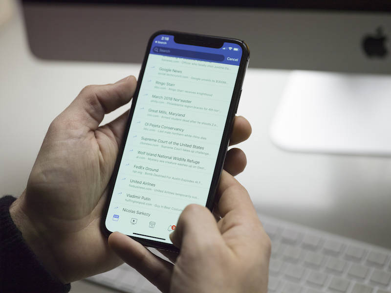 Man sorting through emails on his phone.